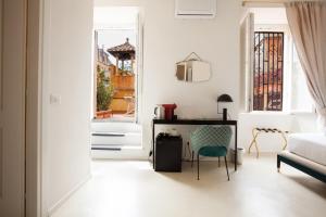 a white living room with a desk and a chair at Ripagrande a Trastevere in Rome