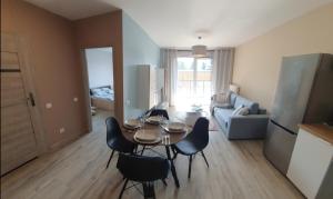 a kitchen and living room with a table and chairs at Cozy Apartment Gdynia in Gdynia