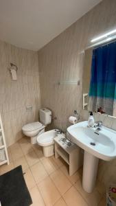 a bathroom with a sink and a toilet and a mirror at Apartments Paradise Lloret in Lloret de Mar