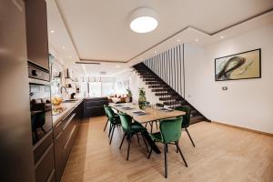 una cucina e una sala da pranzo con tavolo e sedie verdi di Villa Nola Luxury Vodice a Vodice