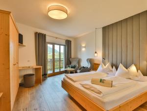 シェーナにあるHotel Weingut Innerleiterhofの大きなベッドと窓が備わるホテルルームです。