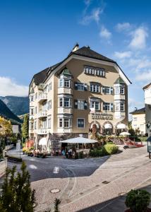 un grand bâtiment dans une rue d'une ville dans l'établissement Classic Hotel Am Stetteneck, à Ortisei