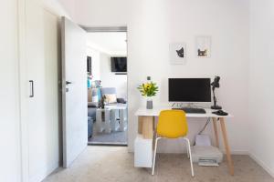 Cette chambre comprend un bureau avec un ordinateur et une chaise jaune. dans l'établissement Villa Magna - seaside villa with pool and sauna, à Trogir