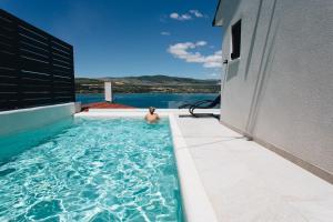 un homme dans la piscine d'une maison dans l'établissement Villa Magna - seaside villa with pool and sauna, à Trogir