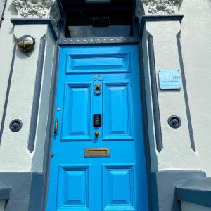 una porta blu sul lato di un edificio di CloudZen a Kent