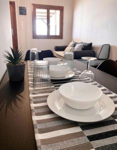 a table with white plates and wine glasses on it at Sea view in Artemis in Artemida