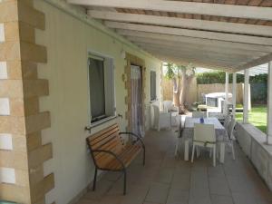 un patio con tavolo, sedie e finestra di L'ULIVO Marzamemi a Noto