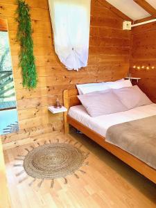 1 dormitorio con 1 cama con pared de madera en CAMPING GALLINA VARJA en Sotta