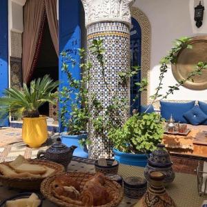 una mesa con platos de comida en una mesa con plantas en Riad Jean Claude en Fez