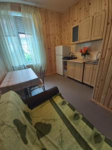 a room with a table and a kitchen with a table and chairs at Гостевой дом Вилла Босфор in Sanzhiyka