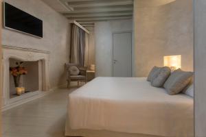a white bedroom with a bed and a fireplace at Relais Venezia in Venice
