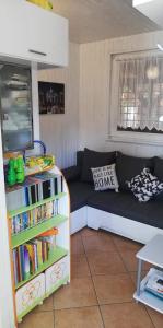 a room with a couch and a book shelf with books at Počitniška hišica Petra in Podčetrtek