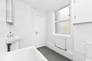 a white bathroom with a bed and a sink at Covent Garden & Soho, Cosy & Cool, Spacious Apartment in London