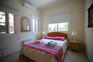 een slaapkamer met een bed met roze en blauwe kussens bij Unique Beach Luxurious Villas in Ayia Napa
