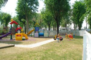 un parque infantil con niños jugando en un parque en Happy Camp Mobile Homes in Camping Laguna Village, en Caorle