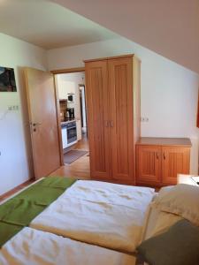 - une chambre avec un grand lit et des placards en bois dans l'établissement Landgasthof Hubertusstubn, à Sankt Michael im Lungau