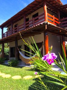 una casa con una hamaca delante en Pousada Das Roseiras, en Barra Grande