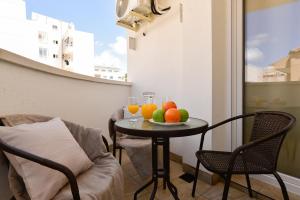Apartments CURA BEACH في توريفايجا: طاولة مع الفاكهة والمشروبات على شرفة