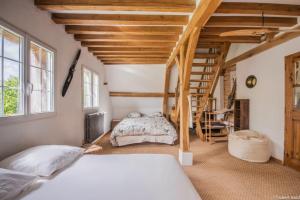 1 dormitorio con 2 camas y escalera de caracol en Gîte Le Bibosien Normandie Dieppe, en Sauqueville
