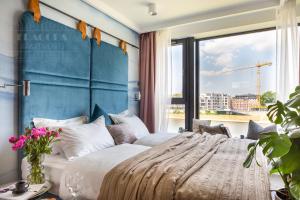 a bedroom with a large bed and a large window at Fragola Apartments Vistula View in Kraków