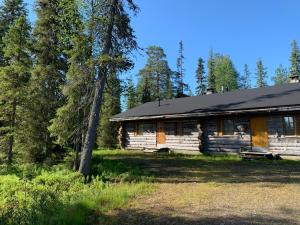 a log cabin in the woods next to some trees at Logwood Chalet in Luosto