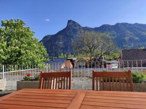 een houten tafel met twee stoelen en een berg bij Ferienunterkünfte Beim Posthalter in Oberammergau