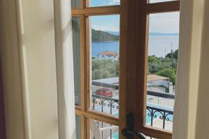 a room with a window looking out at the water at Panormos Beach Hotel Skopelos in Panormos Skopelos