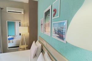a hotel room with a bed and pictures on the wall at Panormos Beach Hotel Skopelos in Panormos Skopelos