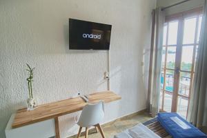 a room with a desk and a tv on the wall at Panormos Beach Hotel Skopelos in Panormos Skopelos