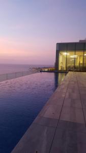 a building with a swimming pool next to the ocean at H2 Hyatt Vista Mar in Cartagena de Indias