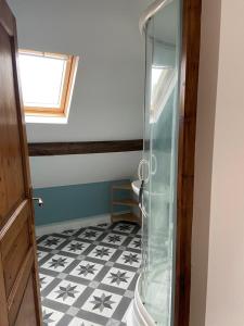a bathroom with a shower and a black and white tile floor at Gîte La Roche in Reffuveille