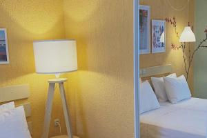 a bedroom with a bed with a lamp next to it at Panormos Beach Hotel Skopelos in Panormos Skopelos