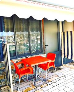 una mesa roja y sillas sentadas en un balcón en Vila Aliaj beautiful room for 2 with air conditioning, en Durrës