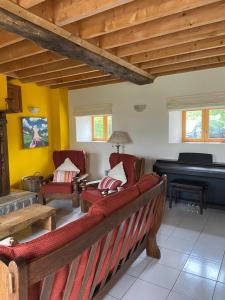 a living room with a couch and a piano at Gîte La Roche in Reffuveille