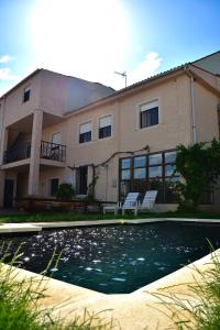 a house with a swimming pool in front of a building at Donde Victor Luna in Granja de Moreruela