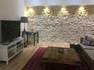 a living room with a large stone wall at Oustau du Ventoux in Bédoin