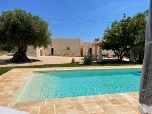 a swimming pool in front of a house at Trullo Nadia Ostuni in Ostuni