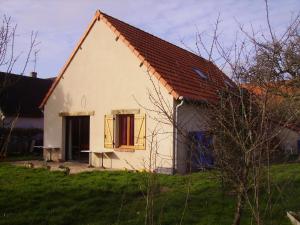 a small white house with a window and a table at Au Grand Pré in Theillay