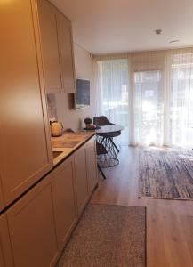 a kitchen with white cabinets and a table in a room at Orange Studio in Juodkrantė