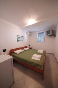 a bedroom with a bed and a television in it at Guest house Zenović in Petrovac na Moru