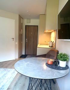 a table in the middle of a room with a kitchen at Orange Studio in Juodkrantė