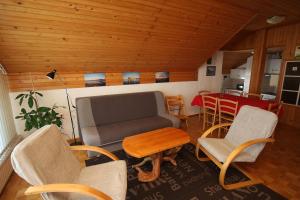 uma sala de estar com um sofá, cadeiras e uma mesa em Apartment Jezerka em Cerknica