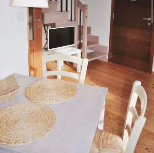 a white table with two chairs and a desk with a computer at Casa Griunit in Capriva del Friuli