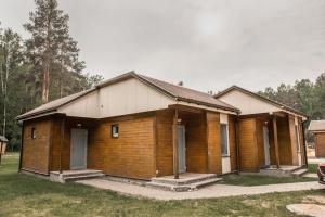 a small wooden house in a yard with trees at Camping & Camper place Pasvalys in Pasvalys