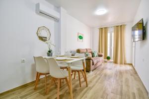 uma sala de jantar com uma mesa branca e cadeiras em Apartments CURA BEACH em Torrevieja