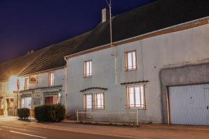 a white building on a street at night at Le loup qui dort in Longwy-sur-le-Doubs