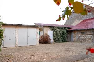 una casa con dos puertas de garaje en un patio en Le loup qui dort, en Longwy-sur-le-Doubs