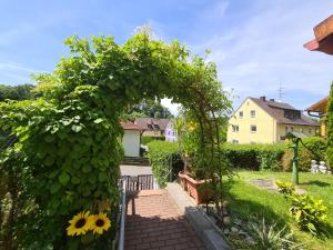 um jardim com um arco com um girassol em Appertment Bärenstein 2 em Gößweinstein
