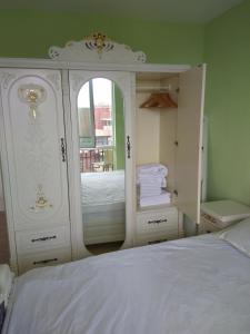 ein Schlafzimmer mit einer weißen Kommode und einem Bett in der Unterkunft Апартаменты Талиана Бич курорта Елените in Elenite