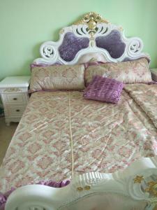 uma cama com uma cabeceira branca e almofadas roxas em Апартаменты Талиана Бич курорта Елените em Elenite